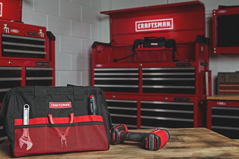 Photo of Craftsman tool bag CMST5518 with red mesh pockets and tools in workshop setting.