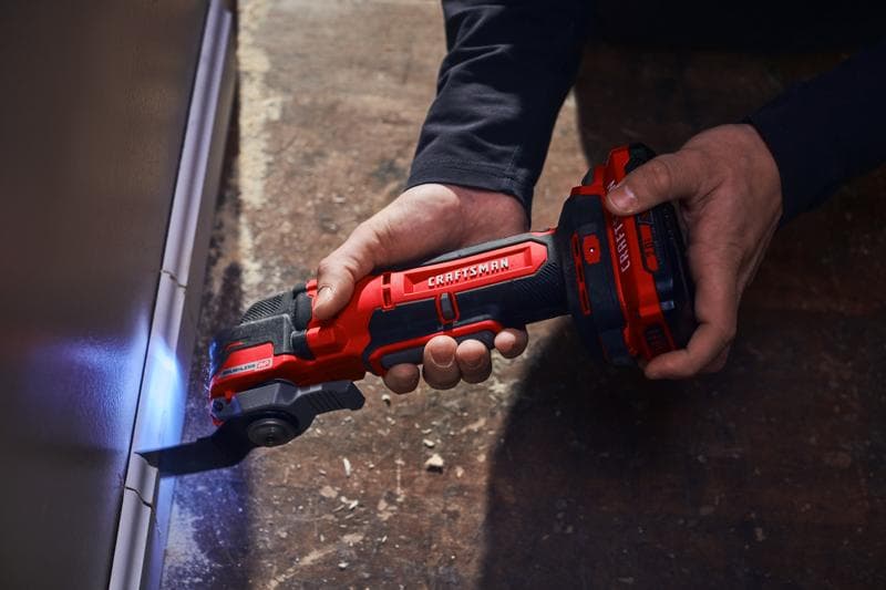 Photographie de l'outil oscillant sans fil Craftsman CMCE565B en utilisation, coupant près d'un mur avec LED.