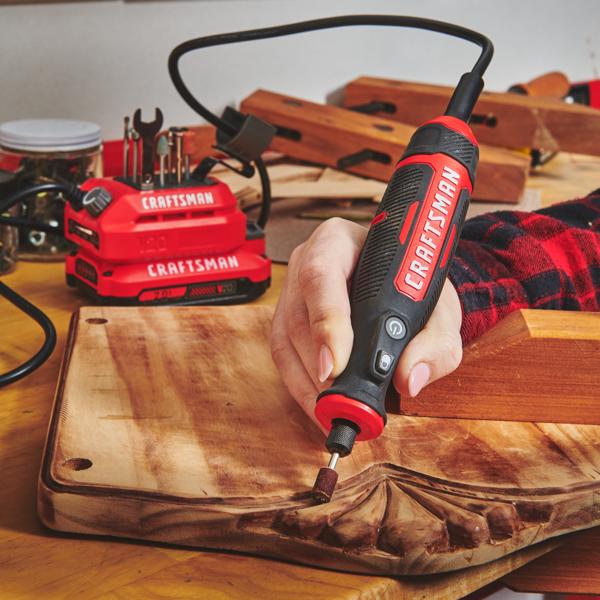 Photo of Craftsman rotary tool CMCE030B used to sand a carved wooden board in a workshop setting.