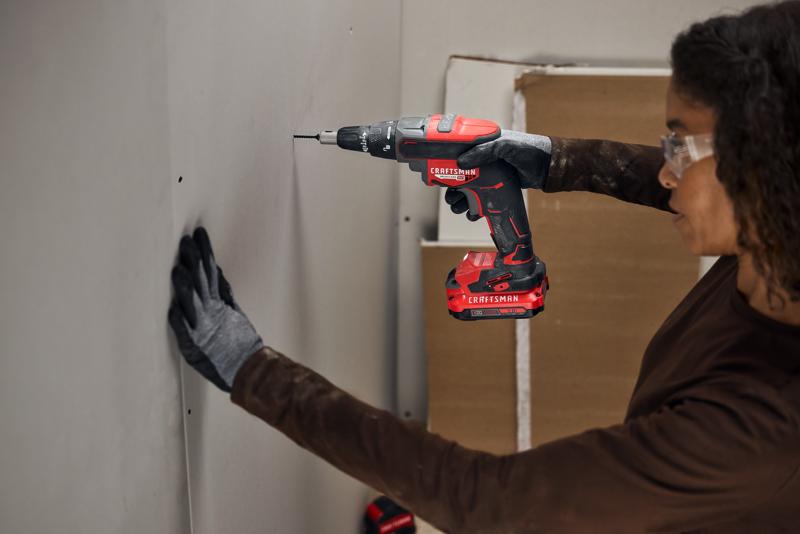 Photo d'une personne utilisant une perceuse sans fil Craftsman CMCF600B pour visser dans une cloison sèche.