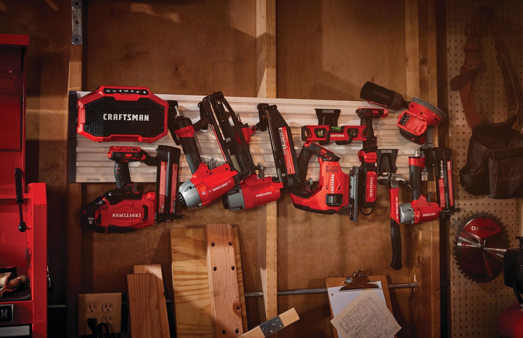 Photo of multiple Craftsman power tools and nailers hanging on a workshop wall, SKU CMST22000, wide angle.