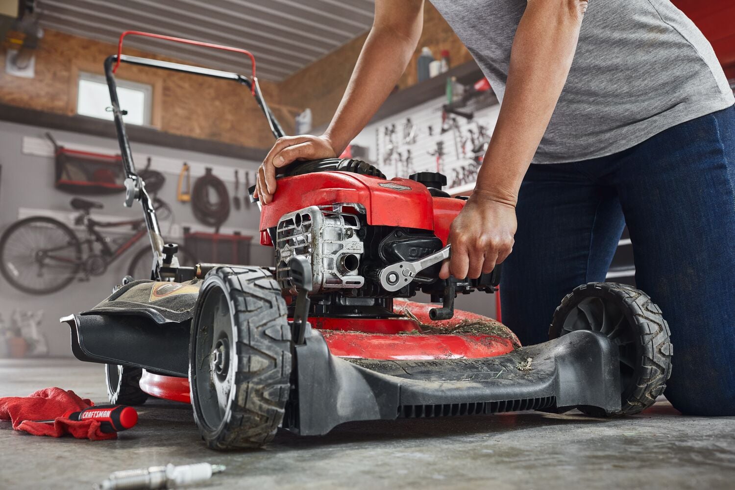 Photo of CRAFTSMAN ratchet tool CMMT86722 used to repair a red lawn mower in a garage setting.