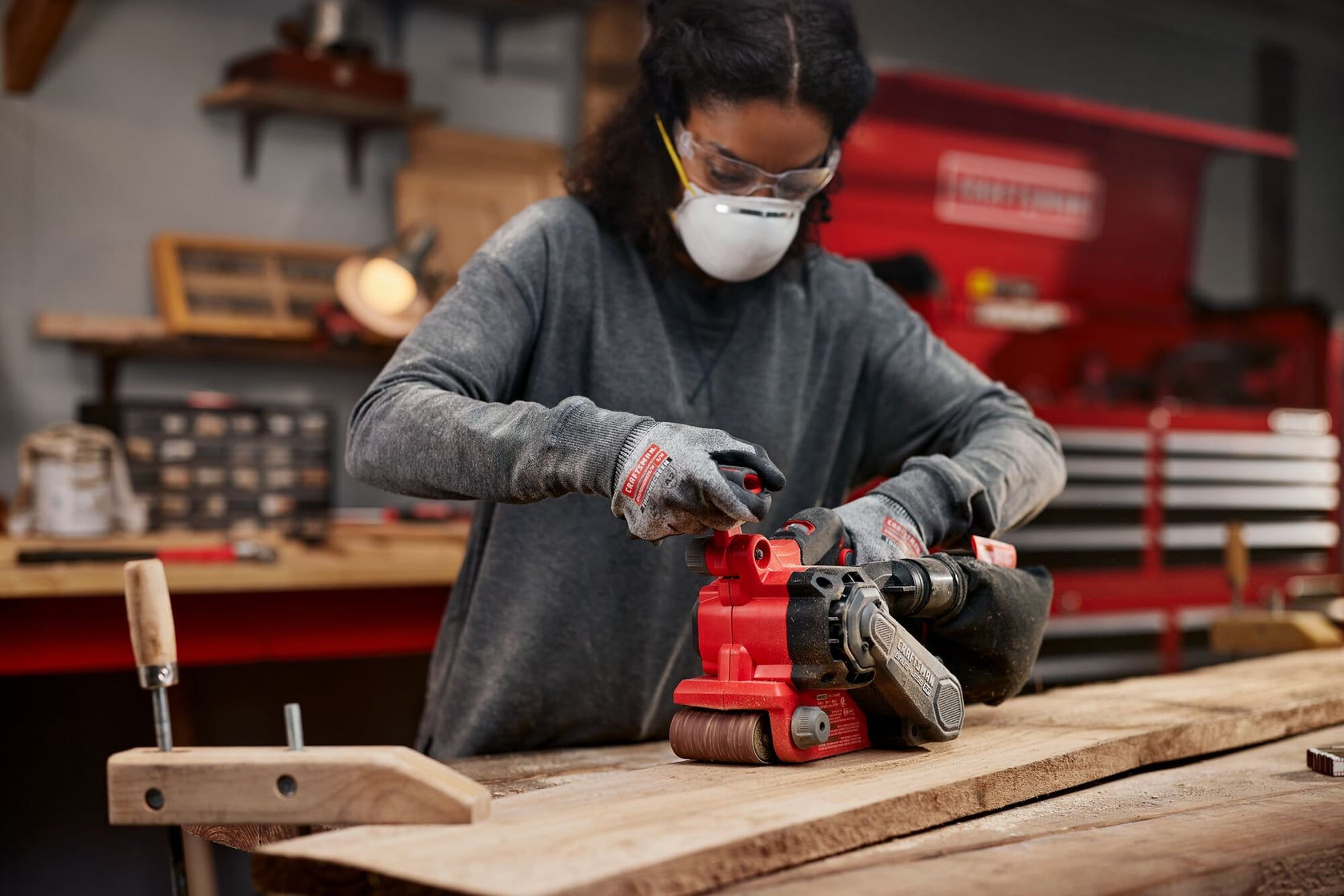 Woman using Craftsman Brushless RP Belt Sander on wood