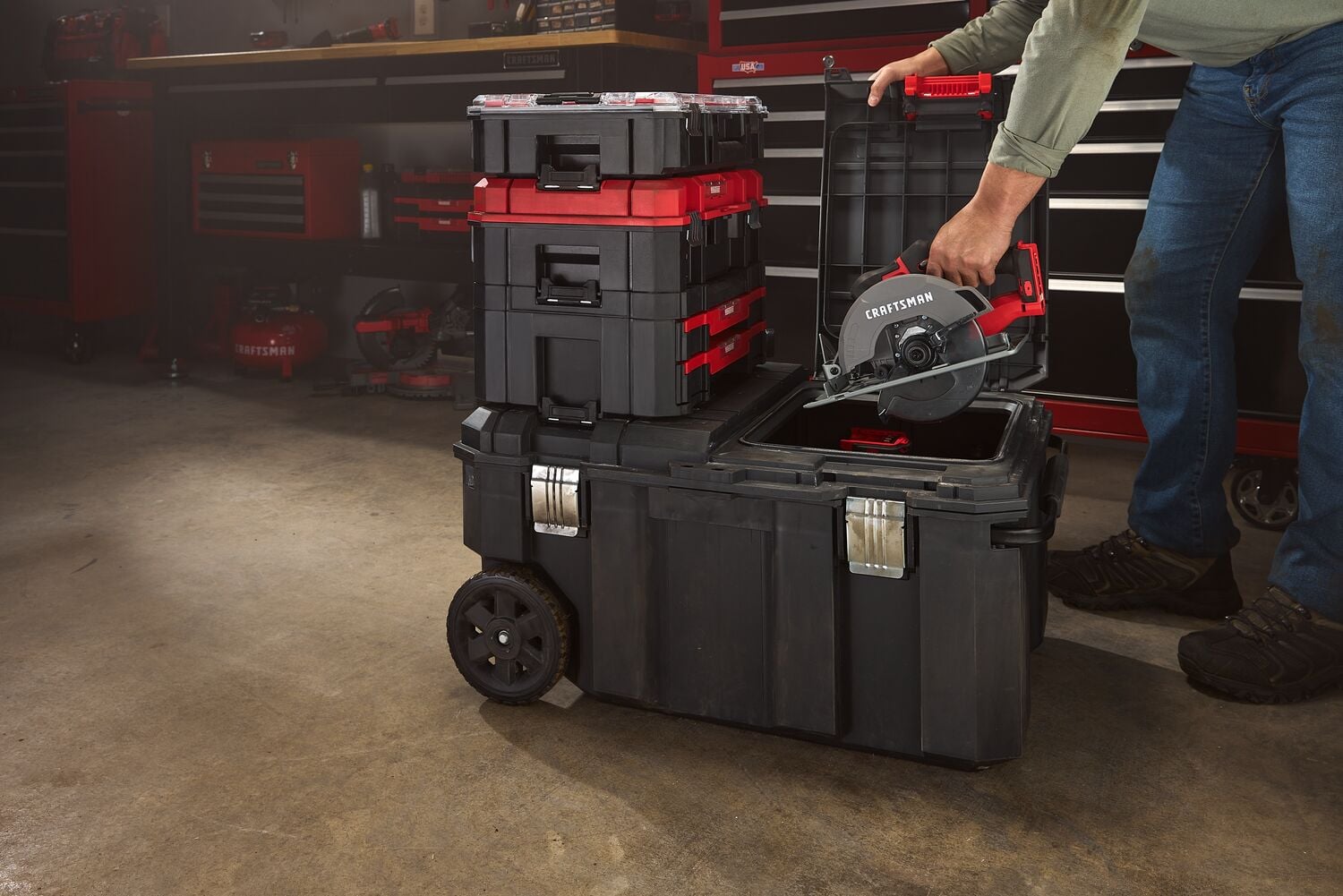 Photo of Craftsman CMST17870 stackable black and red toolbox set in a workshop, one box open holding a circular saw.