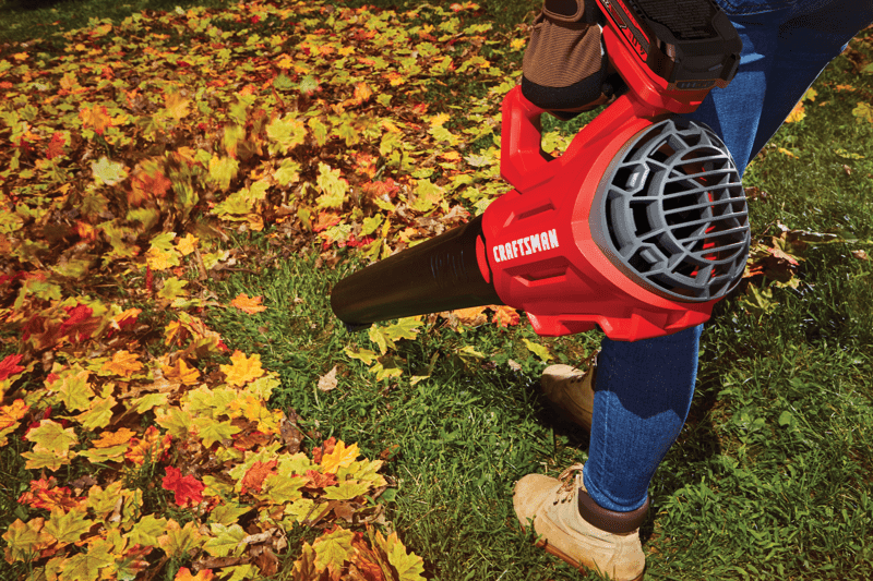 Person using CRAFTSMAN V20* Cordless Axial Leaf Blower Kit in yard