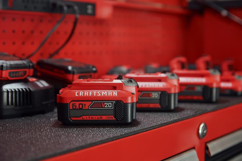 Photo de batterie lithium-ion Craftsman V20 CMCB206, 6.0Ah, rouge et noire, sur établi.
