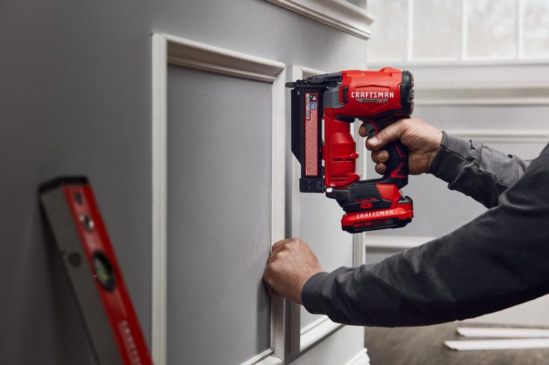 Photo de la cloueuse à brads sans fil Craftsman CMCN623B utilisée pour installer une moulure décorative murale en intérieur.