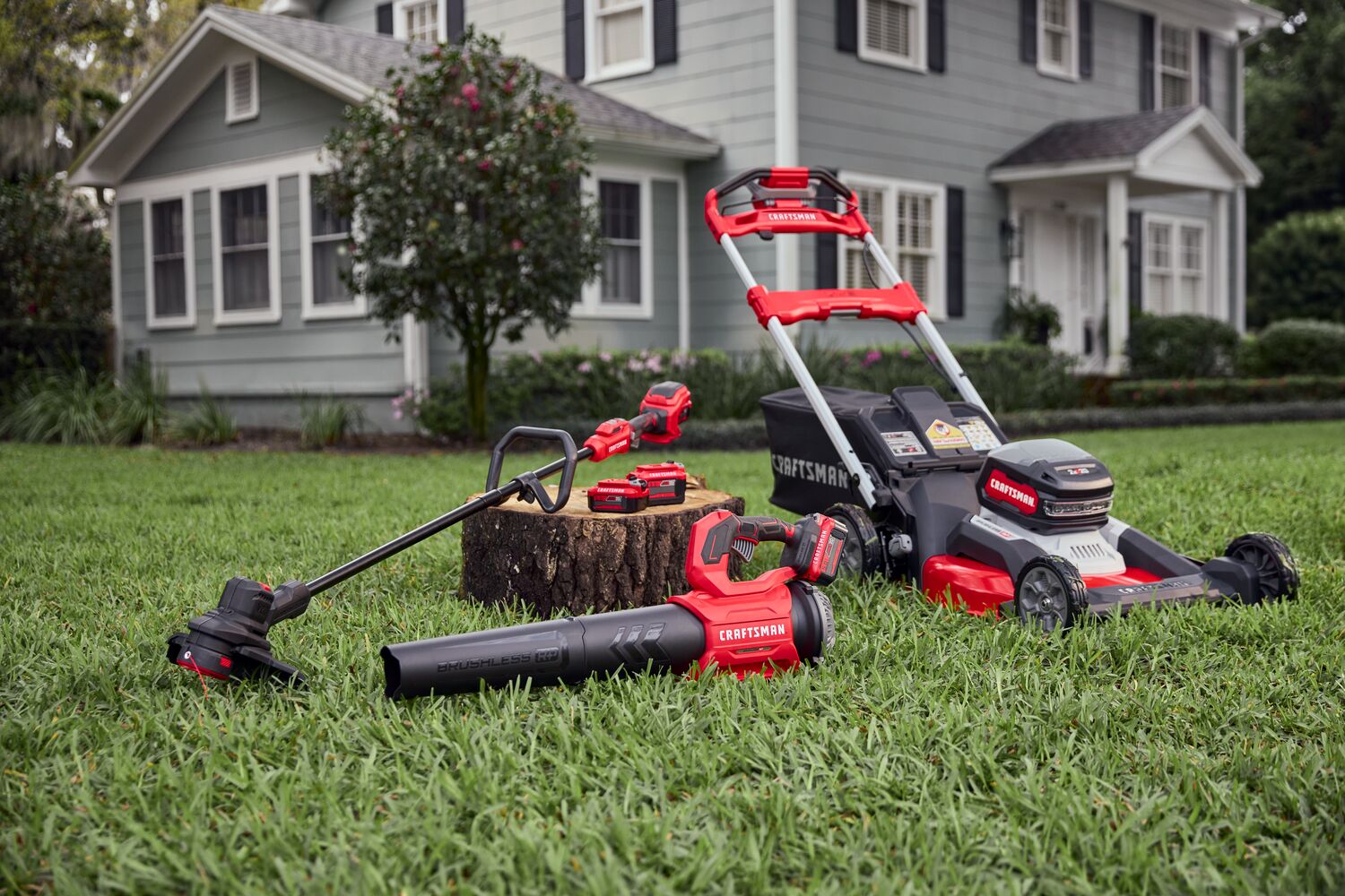 Assorted CRAFTSMAN V20 outdoor power equipment laid out in yard.
