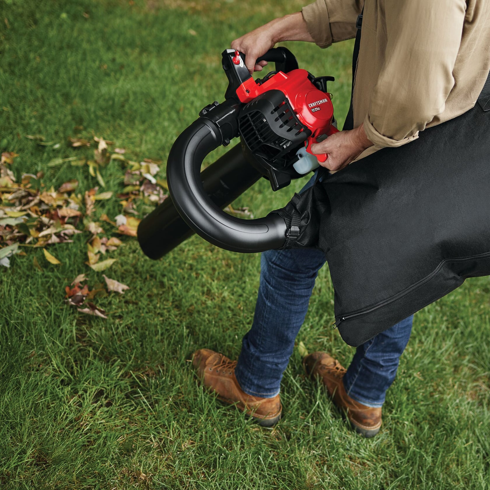 Photographie du souffleur et aspirateur de feuilles CRAFTSMAN 41AR7BVM791 utilisé sur gazon avec sac de collecte.