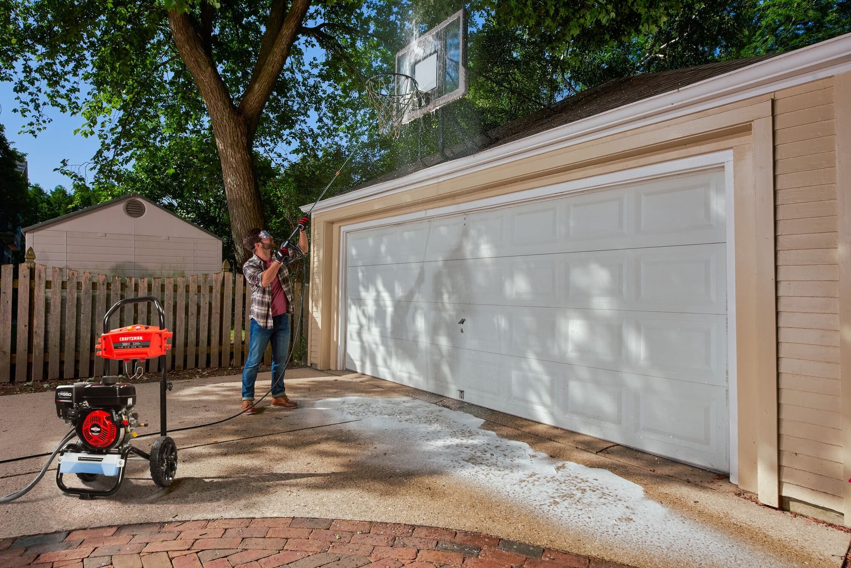 Photo du nettoyeur haute pression Craftsman CMXGWAS020790 utilisé pour nettoyer une porte de garage blanche à l'extérieur.