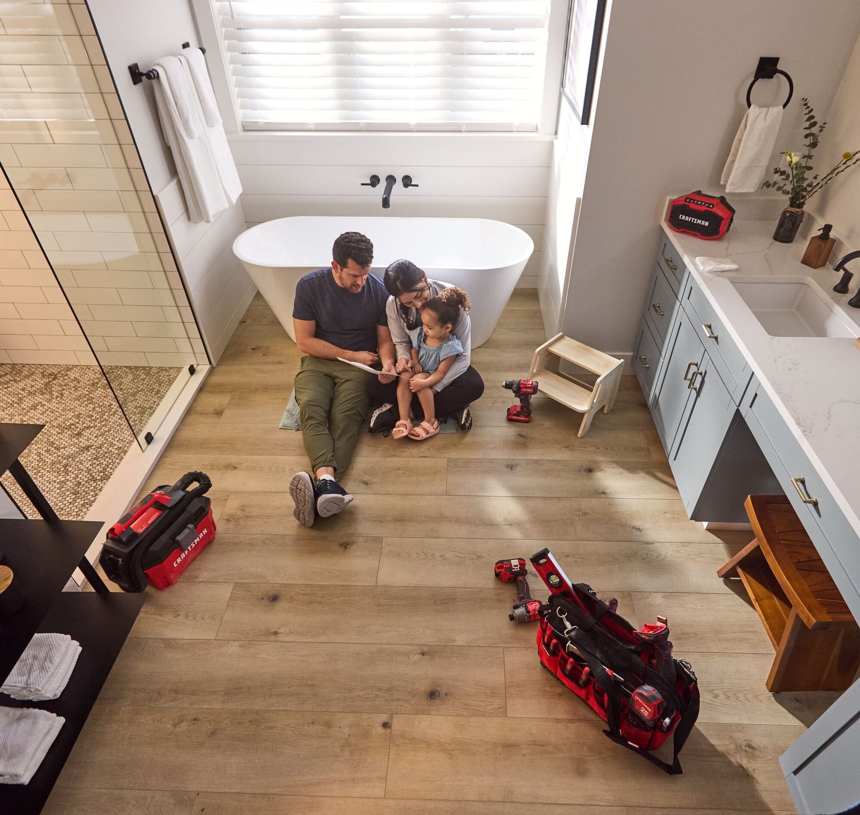 Photo of Craftsman CMST17622 red and black tool bag in a bathroom with visible tools, near a family sitting on the floor.