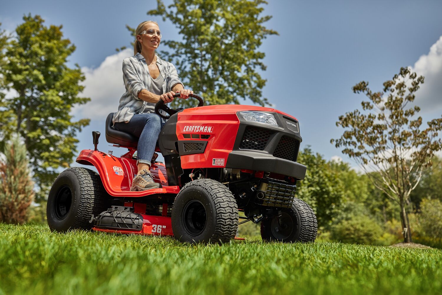 CRAFTSMAN T100 36 In. 11.5 Hp* Gear Drive Riding Mower mowing in yard female wearing jeans and plaid