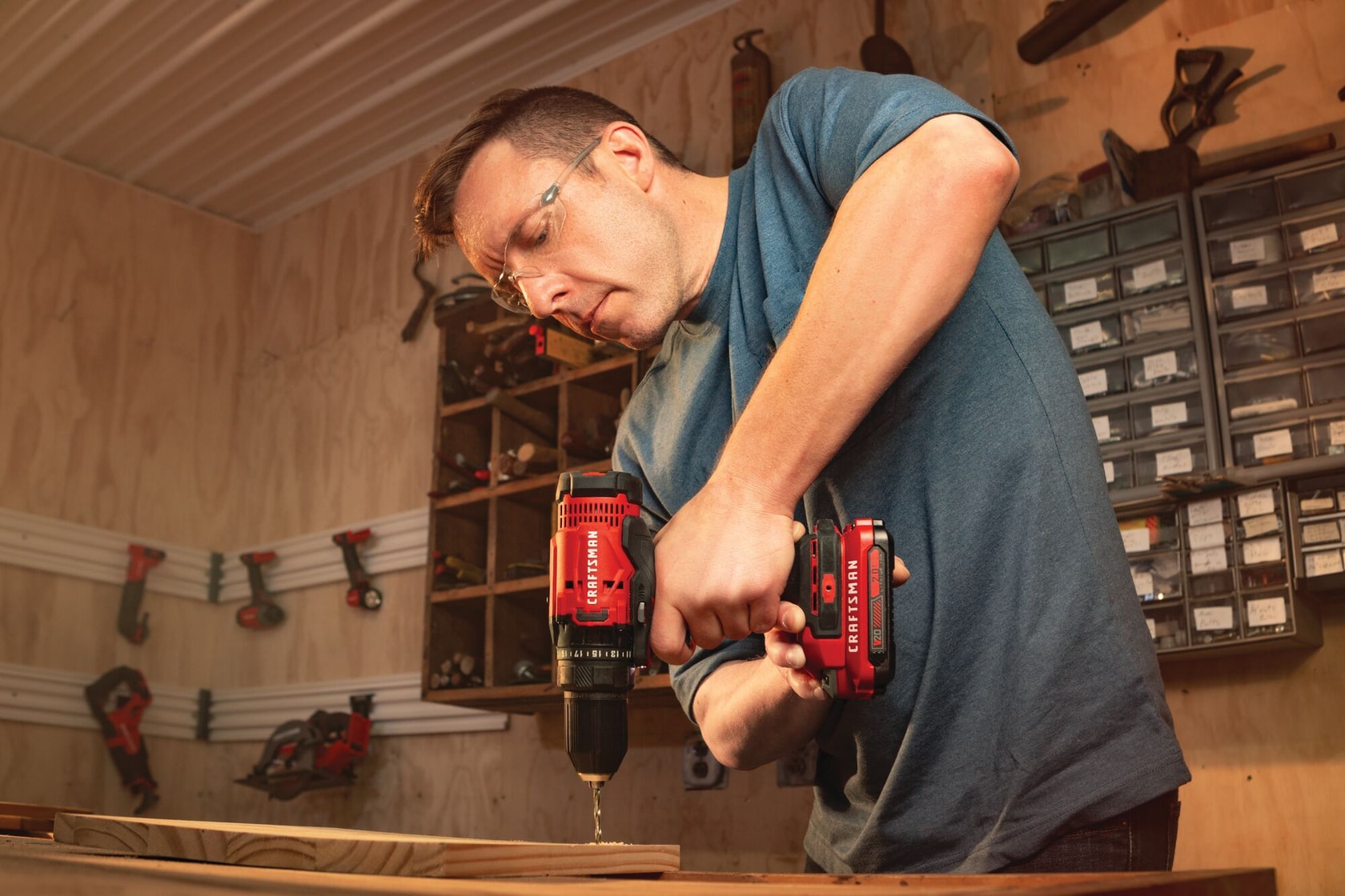 Cordless half inch drill and driver kit 1 battery being used for drilling in wood by person.