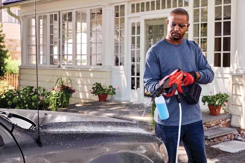 20 volt cordless 350 max P S I power cleaner kit being used by a person to clean a car outdoors.