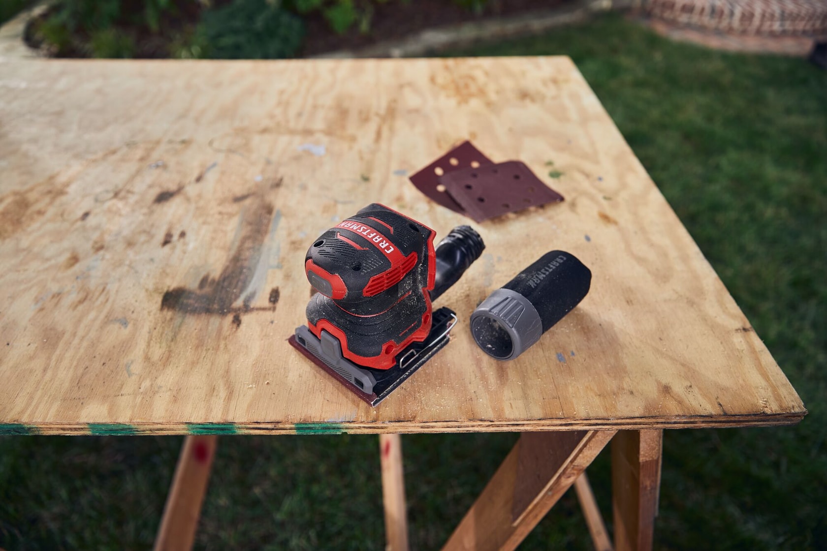 20 volt cordless quarter sheet sander on a work table.